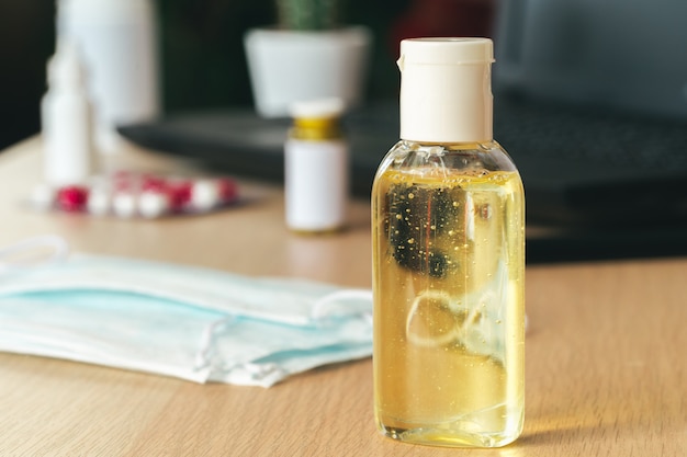 Mesa de trabajo con una pequeña botella de gel de alcohol antibacteriano desinfectante