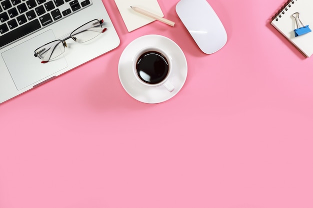 Mesa de trabajo plana con computadora portátil en rosa