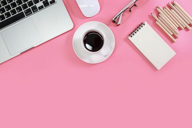 Foto mesa de trabajo plana con computadora portátil en rosa