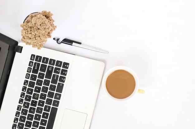 Mesa de trabajo con una taza de café aislado sobre fondo blanco.