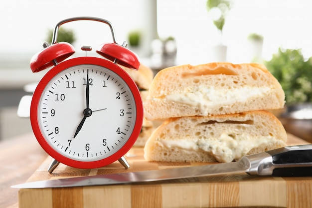 Mesa um despertador e café da manhã pão e molho