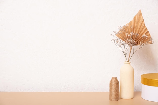 Mesa vacía y jarrones de hierba seca y hojas de palma sobre fondo blanco diseño de interiores para el hogar Mesa en blanco para sus diseños