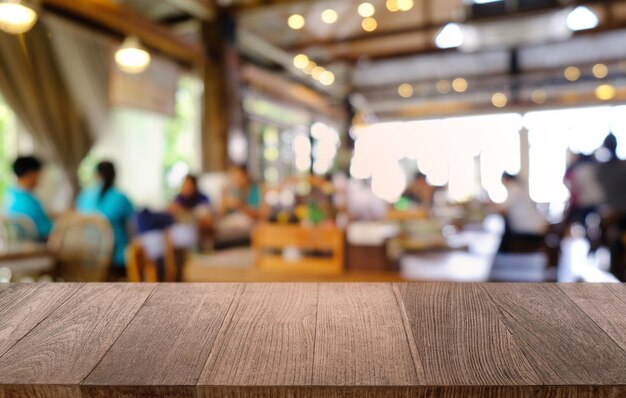 Foto la mesa vacía de madera oscura frente al fondo abstracto y borroso del restaurante se puede usar para exhibir o montar sus productos mock up para espacio