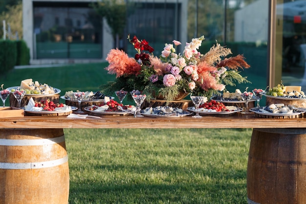 Foto mesa de variedad de quesos con surtido de quesos, bayas y frutas en la mesa exterior vista frontal