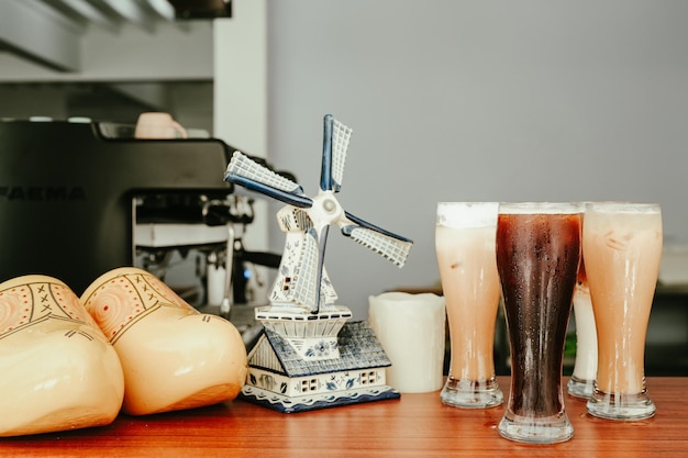 Una mesa con unos vasos de cerveza y un molino de viento encima