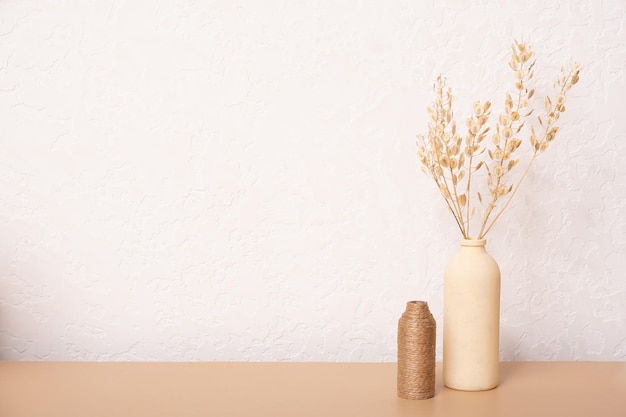 Mesa vazia e vasos de grama seca e folhas de palmeira em fundo branco design de interiores para casa Mesa em branco para seus projetos