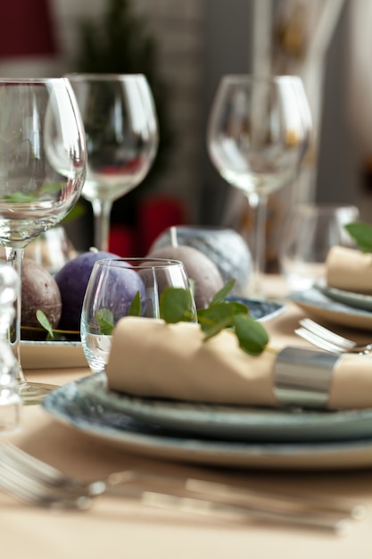 Mesa con velas y ramas de plantas.