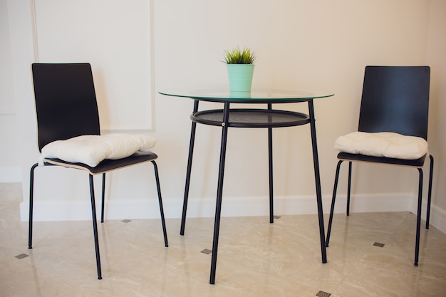 Foto mesa de vidrio y sillas modernas blancas en el comedor.