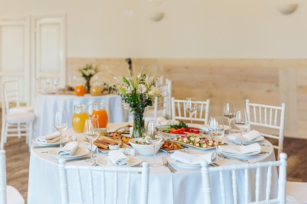 Foto mesas bellamente puestas con vasos y electrodomésticos para una boda u otro evento