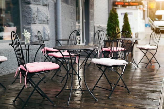 mesas de café vacías en la calle durante la lluvia. enfoque selectivo