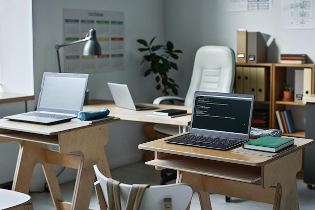 Mesas com computadores para aula de TI