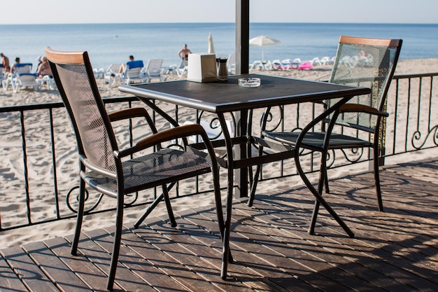 Mesas de restaurante no terraço perto da praia