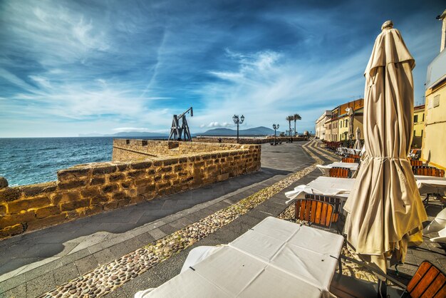 Mesas e cadeiras de restaurante em Alghero à beira-mar Itália