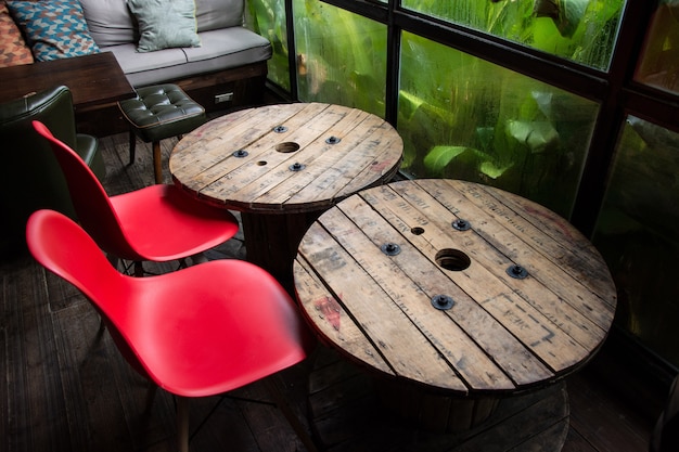 Mesas de madera y sillas rojas en la cafetería.