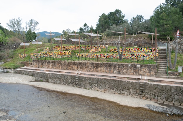 mesas de picnic hechas de piezas de baldosas de cerámica de colores brillantes construidas junto a una piscina natural