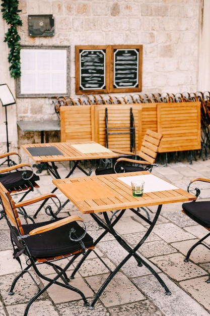 Mesas plegables de madera y sillas forjadas de un café de la calle en el casco antiguo de dubrovnik, croacia