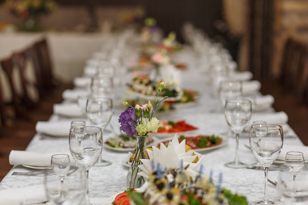 Mesas servidas con mantel blanco y platos vacíos