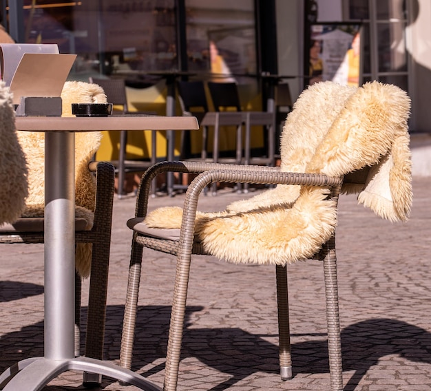 Mesas vacías afuera entre las horas del almuerzo a lo largo de un callejón empedrado en una ciudad europea una veranda un café