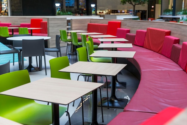 Mesas vacías y cómodos asientos en un patio de comidas en un centro comercial