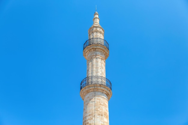 Foto mesquita neratze minaret icônico na cidade de rethymno, ilha de creta, grécia, sob a vista de um monumento islâmico