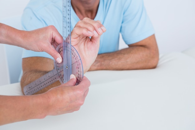 Messendes Handgelenk des Doktors mit Goniometer