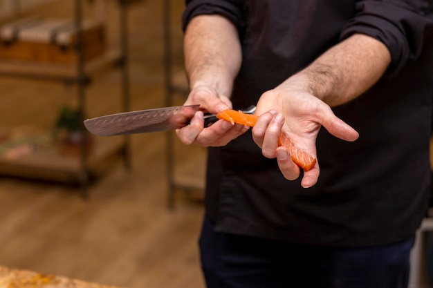 Messer in der Hand schneidet die Lachsnahaufnahme