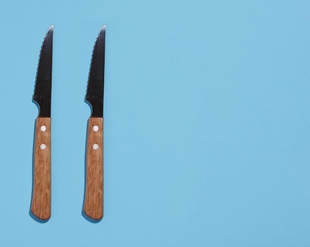 Messer mit einem Holzgriff auf einer Draufsicht des blauen Hintergrundes