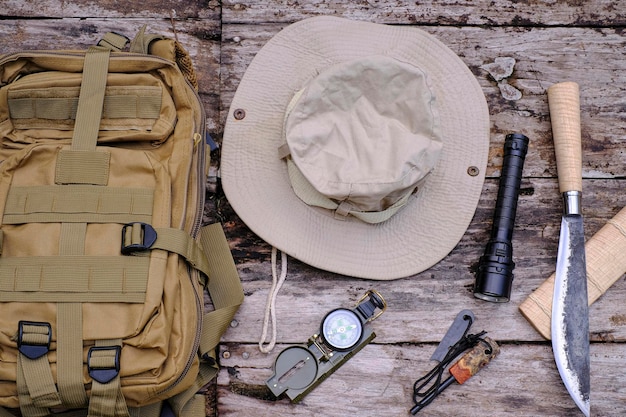 Messer-Rucksack mit Ausrüstung für das Überleben im Wald auf dem alten Holzhintergrund