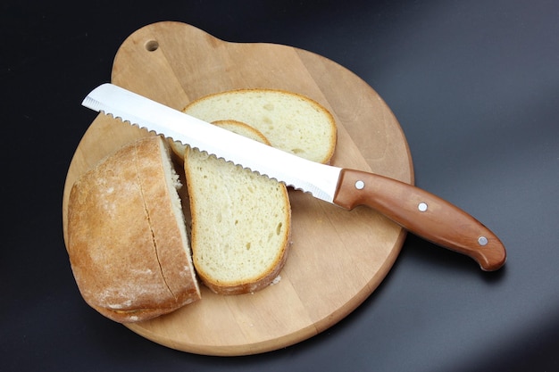 Messer schneidet einen Laib Brot in Scheiben Saatbrot hausgemachtes Brotschneidebrot