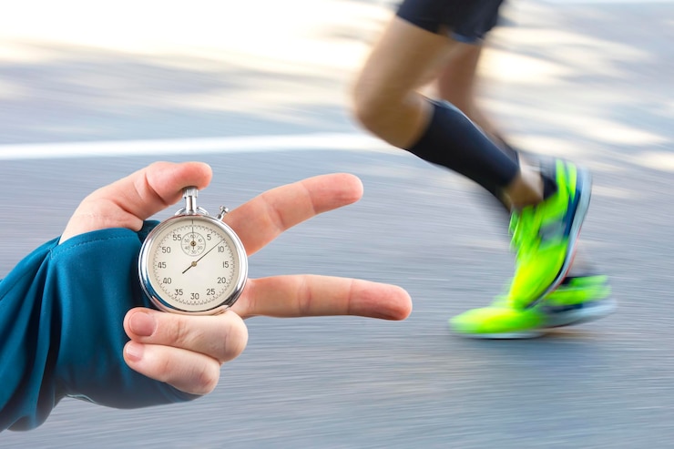 Foto messung der laufgeschwindigkeit eines athleten mit einem mechanischen stoppuhrzeiger mit einer stoppuhr auf dem hintergrund der beine eines läufers