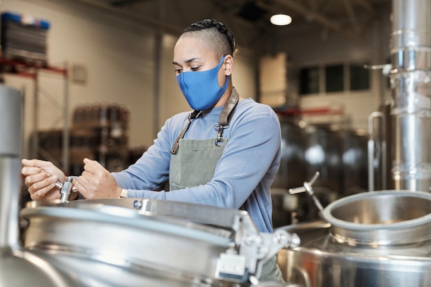 Mestre cervejeiro feminino na fábrica de fabricação de cerveja