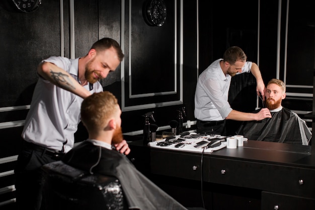 Mestre corta cabelo e barba na barbearia