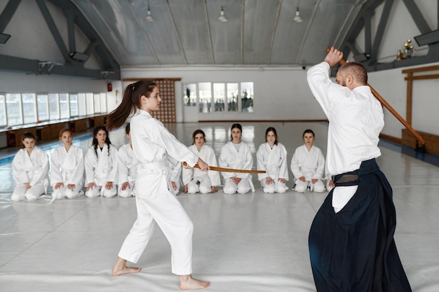 Menina E Mestre Aikido Lutando Com Espada De Madeira Durante a