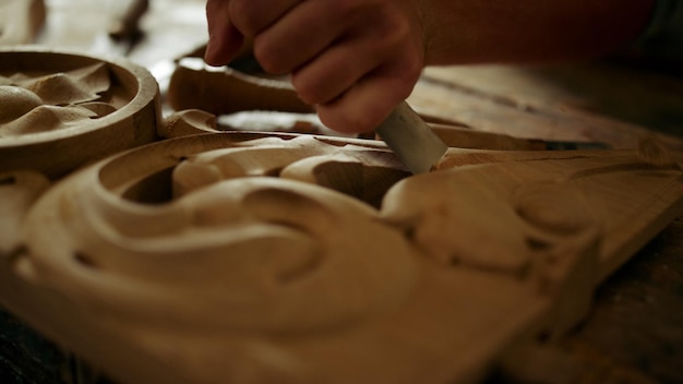 Mestre de madeira desconhecido esculpindo em madeira em oficina de carpintaria em câmera lenta Closeup carpinteiro não reconhecido decorando produto de madeira em estúdio Mãos masculinas usando ferramentas em ambientes fechados