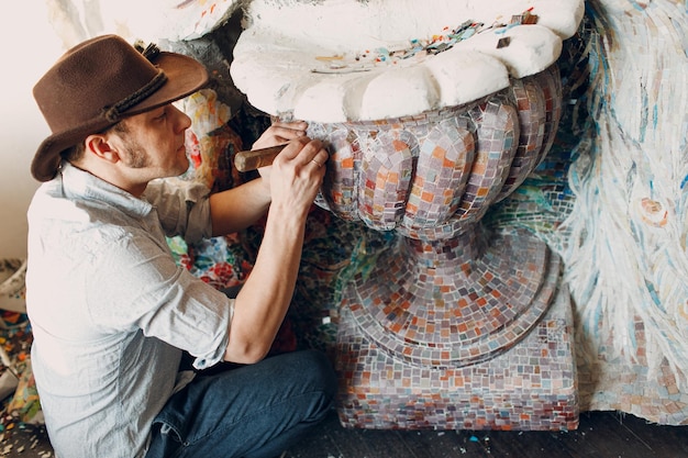 Mestre de mosaicos de homem fazendo painel de mosaico de vidro smalt Mosaicista masculino no trabalho