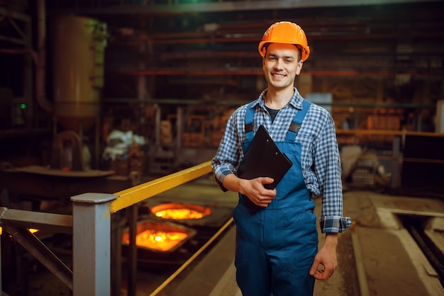 Foto mestre em capacete em forno com metal líquido, fábrica de aço, indústria metalúrgica ou metalmecânica, fabricação industrial de produção de ferro na usina