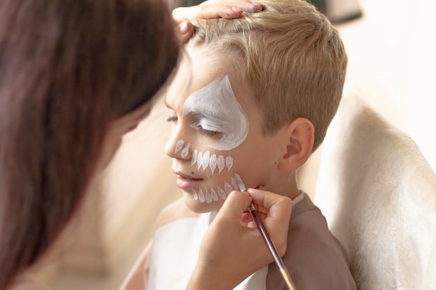 Mestre fazendo maquiagem aquática em meninos, pintura facial, crianças