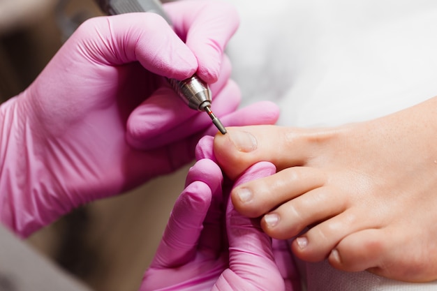 Mestre feminino fazendo pedicure para um cliente em um salão de beleza