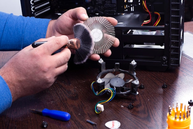 Mestre limpa o ventilador de computador empoeirado Conceito de tecnologia de computador