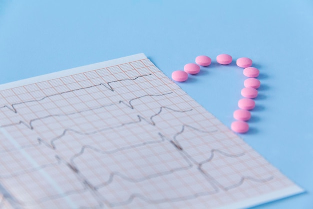 Metade de um coração feito de drogas rosa e um eletrocardiograma do coração em um fundo azul O conceito de estilo de vida saudável e exame médico oportuno
