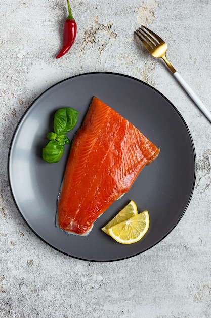 Metade do filé de salmão salgado em um prato cinza Alimentação saudável