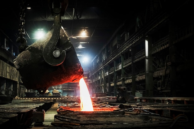 Metal quente é derramado de uma concha em uma planta metalúrgica