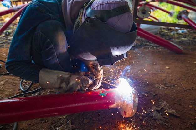 El metal de los trabajadores masculinos de soldadura es parte de la tubería de reparación de agua contra incendios