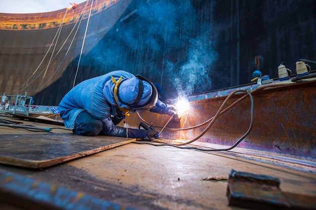 El metal de los trabajadores de soldadura es parte de la construcción de la viga del tanque del techo de la placa de la maquinaria dentro de los espacios confinados