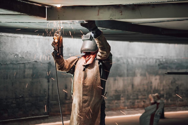 El metal de los trabajadores de soldadura es parte de la construcción de la viga del tanque del techo de la placa de la maquinaria dentro de los espacios confinados