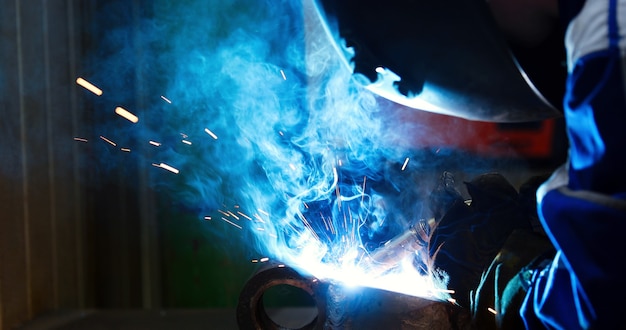 Metallarbeiter, der mit Fackel in der Metallindustriefabrik schweißt
