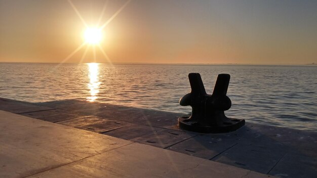 Foto metallbollard am hafen am meer gegen den klaren himmel bei sonnenuntergang