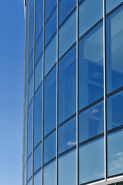 Metallglasteil des Gebäudes gegen den blauen Himmel als abstrakter industrieller Hintergrund