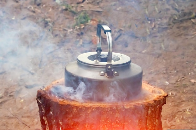 Foto metallkessel, der auf einer provisorischen platte kocht