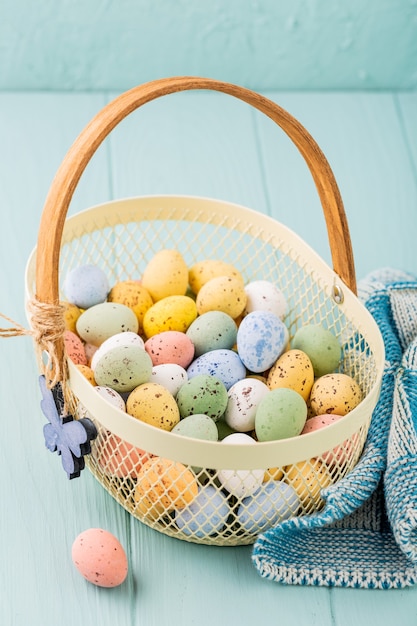 Metallkorb mit bunten Osterwachteleiern. Frühlingsferienkonzept mit Kopierraum